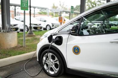 A picture depicting an electric vehicle connected to a charger